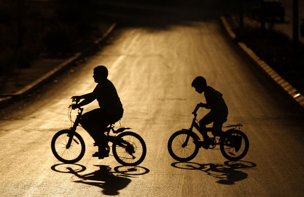 29 May 2009: Ramallah, Waest Bank: Youths ride bicycles during sunset