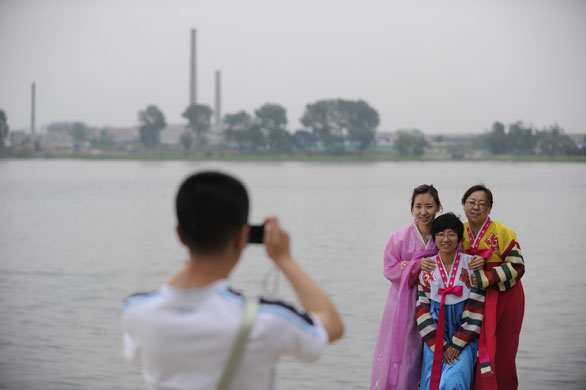 North Korea Border: Chinese tourists at the Yalu river in Dandong, China