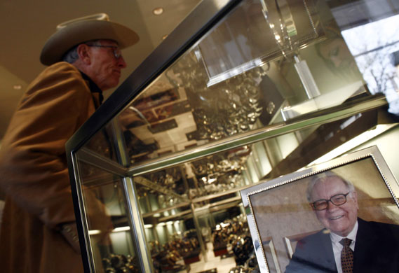 Warren Buffett: A Berkshire Hathaway investor at Borsheim's jewellers next to a photograph of Warren Buffett at a party to launch the company's annual shareholders' meeting in Omaha, Nebraska