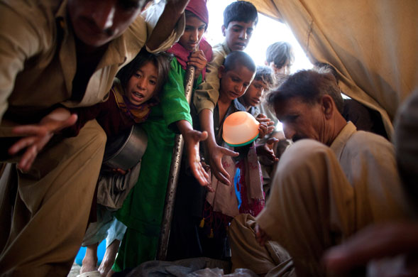 31 May 2009: Swabi, Pakistan: Internally displaced people push into a tent 