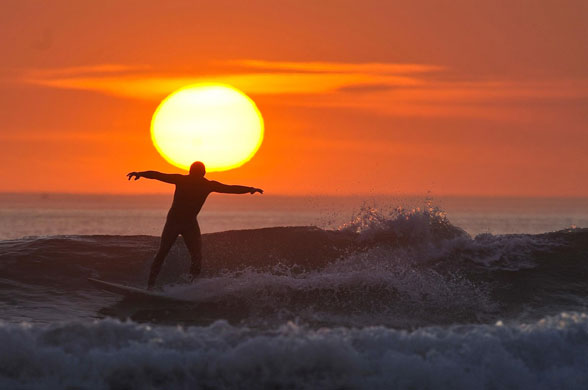 British sunshine: A lone surfer enjoys the last waves of the day