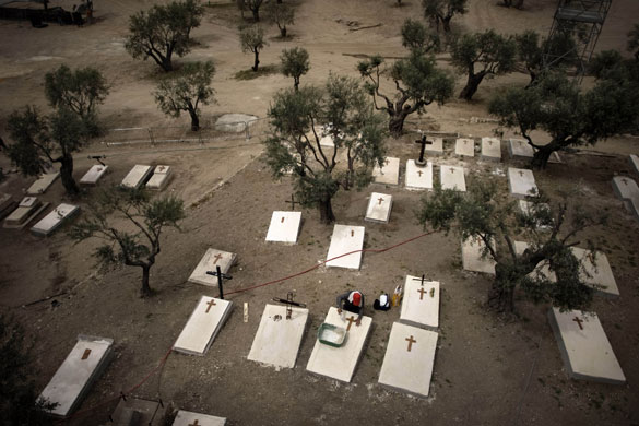 4 May 2009: Israel: A worker puts crosses on graves near the stage for the Papal Mass