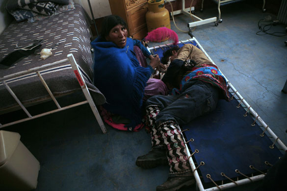 Thinku festival: A  woman sits with her husband who broke his nose in a ritual fight