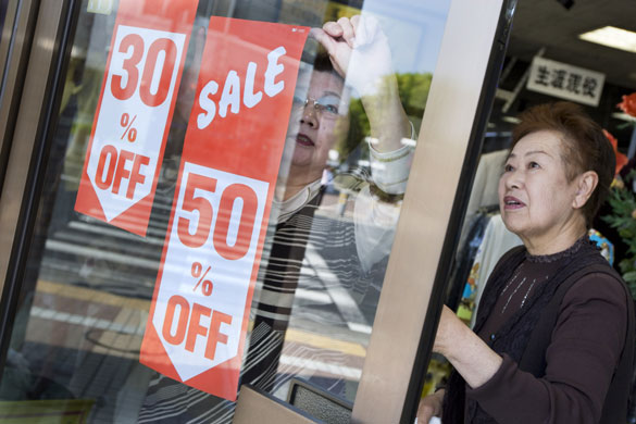 Toyota City: Two women put up sale signs in a clothes shop in Toyota city, Japan