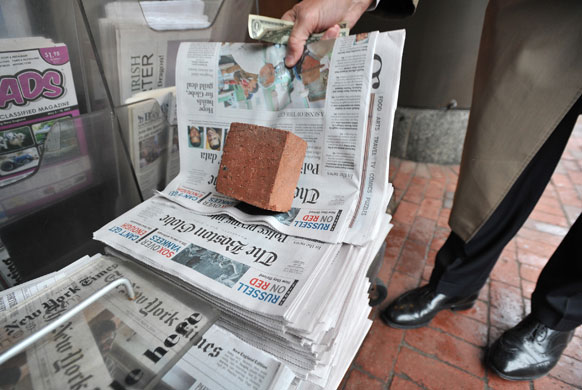 Business week in pictures: A reader buys a copy of the Boston Globe