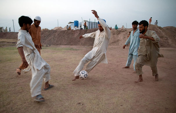 IDP camps Pakistan: Men play soccer at the massive tent city in Jalozai camp