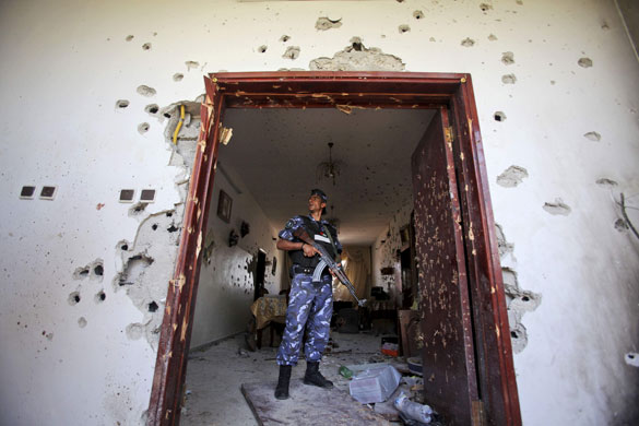 1 June 2009: Qalqilya, West Bank: A police officer examines the damage to a house