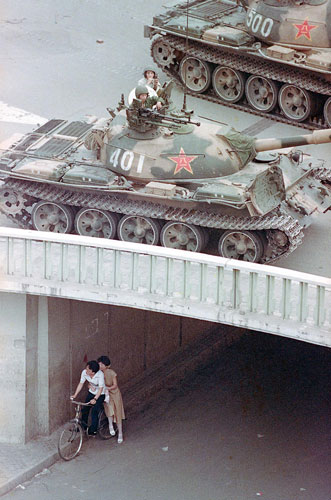 Tiananmen Square: A Chinese couple on a bicycle take cover in an underpass in Beijing