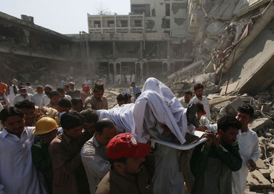 Peshawar bombing: Rescue workers carry the body of a dead man at the Pearl Continental Hotel