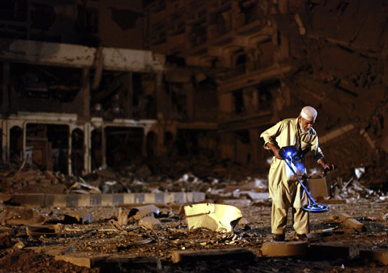 Peshawar bombing: A Pashtun man sorts through debris at the Pearl Continental Hotel 