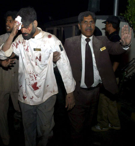 Peshawar bombing: An employee of Pearl Continental Hotel helps his injured colleague