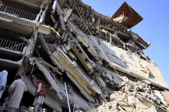 Peshawar bombing: A volunteer, right, and officials stand amid the destruction 