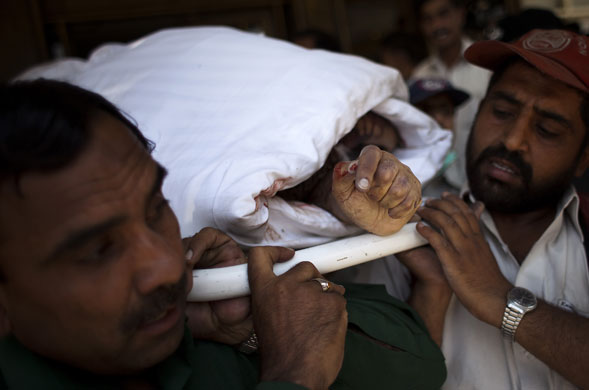 Peshawar bombing: Pakistani rescue members carry a dead body from Peshawar Pearl Continental