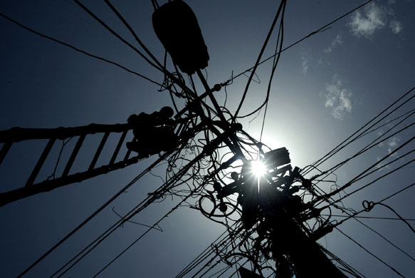 24 hours: Allahabad, India: An electrical linesman repairs cables
