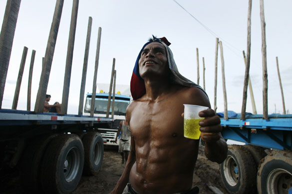 24 hours: Yurimaguas, Peru: A stevedore drinks a cup of soda