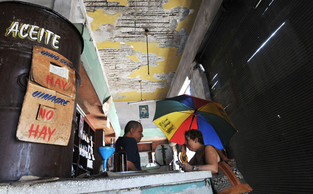 24 hours: Havana, Cuba: A woman asks for food with her ration book