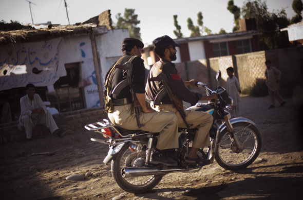 24 hours: Swabi, Pakistan: Police officers patrol on a motorcycle