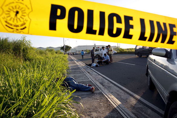 24 hours: Paranaque City, Philippines: Filipino police investigators examine a body