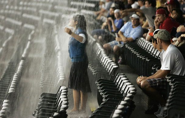 24 hours: Arlington, US: A girl stands in the rain at an American baseball game