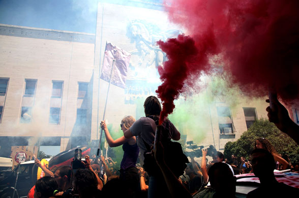 Gaddafi in Rome: Students light flares and throw paint in a protest against Gaddafi's visit