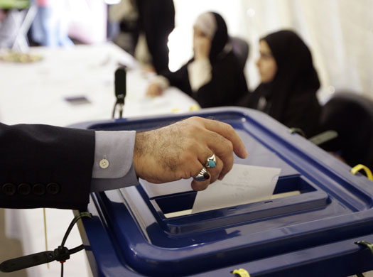 Iraninan elections: A man casts his ballot at the Iranian Consulate in Dubai