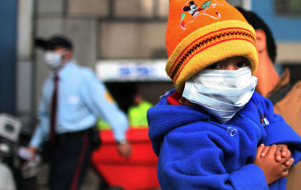 12 June 2009: Bogota, Colombia: A child wears a mask as precaution against swine flu
