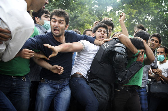 Riots in Tehran: A policeman is held by one of the protestors