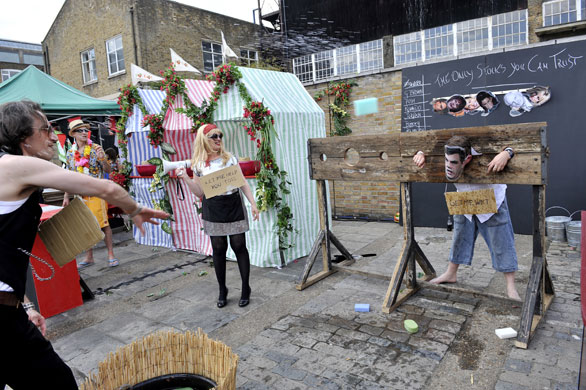 Art Car Boot Fair: Throwing wet sponges at participants in stocks