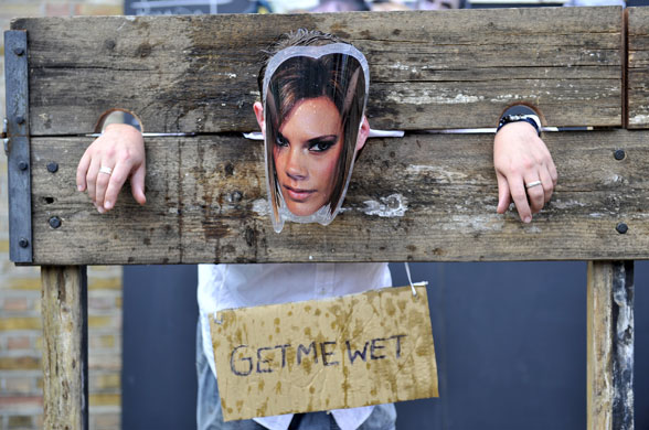Art Car Boot Fair: A man with a Victoria Beckham mask gets a wet sponge thrown at him