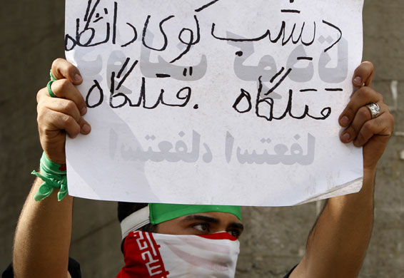 Tehran protest: A student holds a banner at the gates of Tehran university
