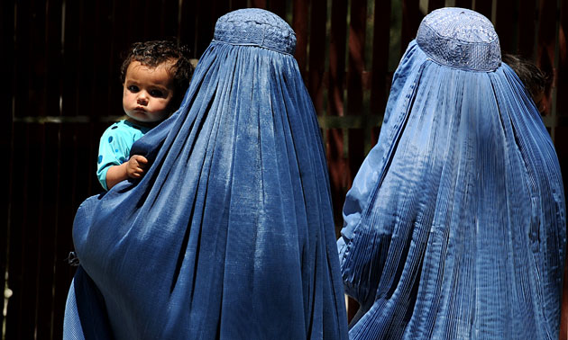 24 hours: Kabul, Afghanistan: Burqa-clad women carry their children