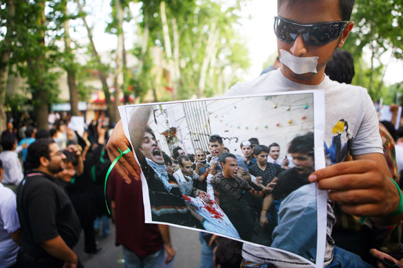 Iranian protests: A supporter of Mousavi holds a picture of a man who had been shot