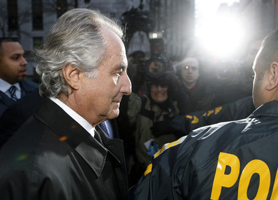 Week in Business: Disgraced financier Bernard Madoff is escorted by police 