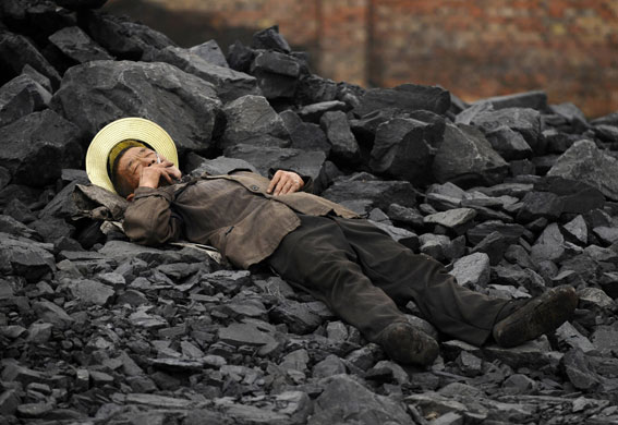 24 hours in pictures: A labourer smokes while taking a rest at a cinder dump in Changzhi China