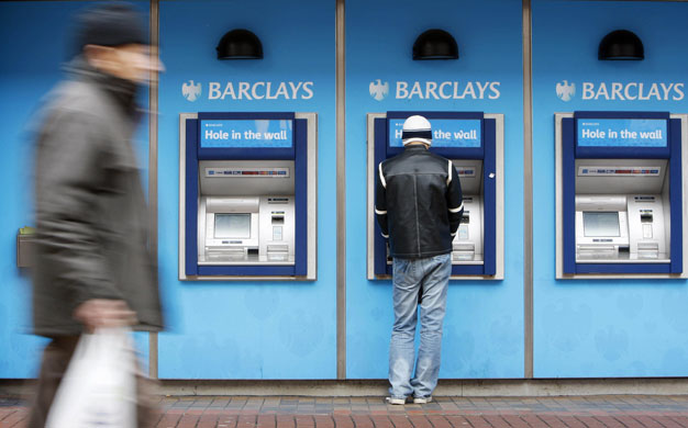 Week in Business: A man uses a cash machine at a Barclays Bank branch in Hounslow, London