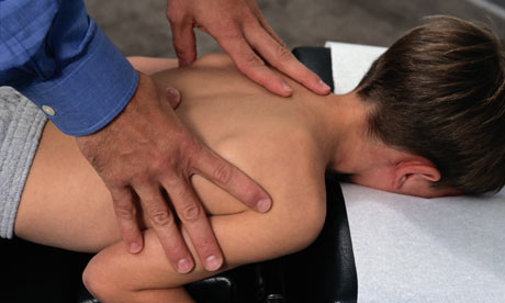 Chiropractor adjusting a boy