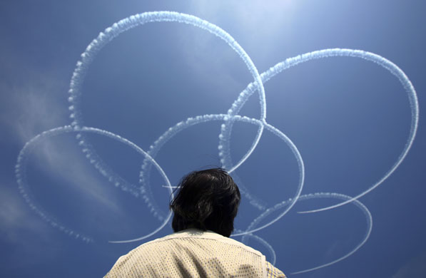 24 hours in pictures: A man watches smokes from Japan Air Self Defense Force