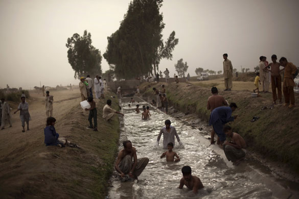 24 hours in pictures: Displaced people in a canal at the Chota Lahore refugee camp