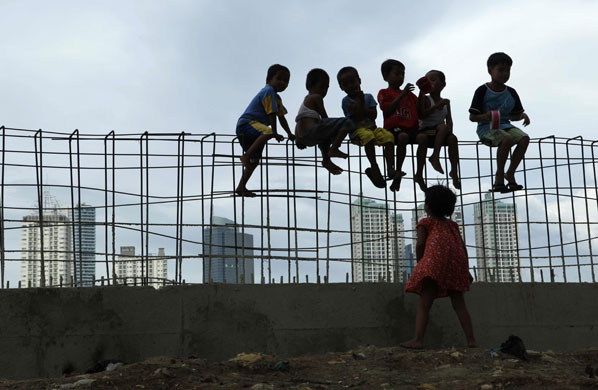24 hours in pictures: Children sit on iron bars at a construction site in Jakarta