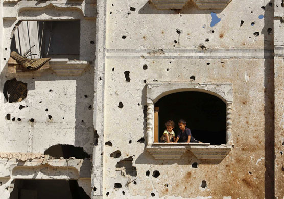 24 hours in pictures: Palestinian children look out of window of damaged house in Rafah