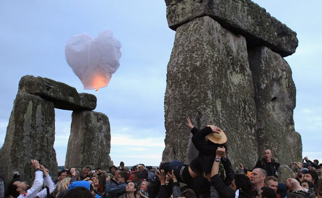Stonehenge solstice: A woman is lifted above the crowd at the summer solstice at Stonehenge