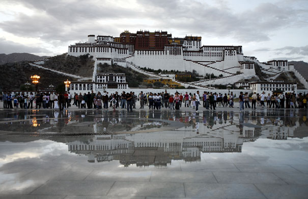 24 hours in pictures: Lhasa, Tibet: Crowds are reflected in water in front of the Potala Palace 