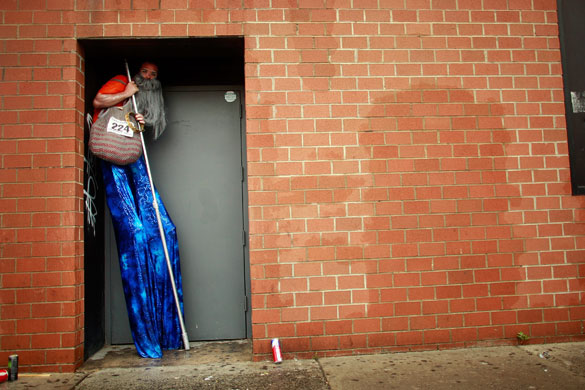 24 hours in pictures: Coney Island, New York City, USA: A stilt walker shelters from the rain
