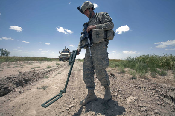 Sean Smith in Afghanistan: American soldiers use a metal detector to search for IEDs on a road
