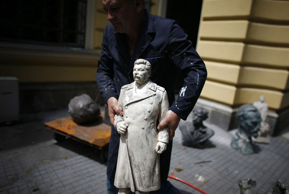 24 hours in pictures: Worker carries a sculpture of Stalin the National Art Gallery in Sofia