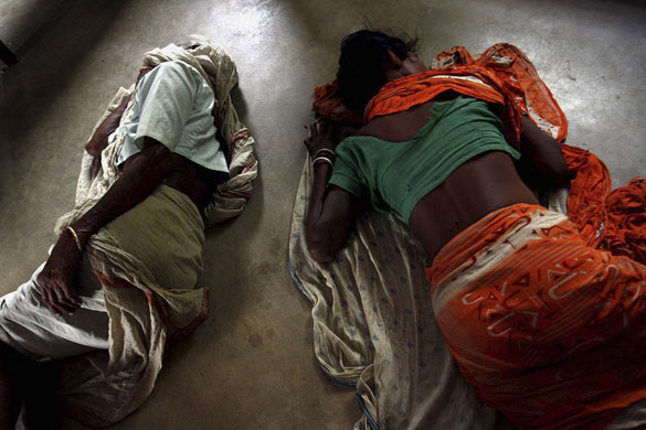 24 hours in pictures: Villagers who have fled their homes sleep at a relief camp at Pirakata