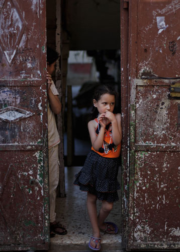 24 hours in pictures: Palestinian girl stands in doorway in Jalazoun refugee camp