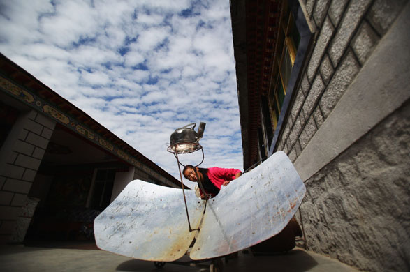 24 hours in pictures: Life in Lhasa A Tibetan girl heats up water with the solar energy