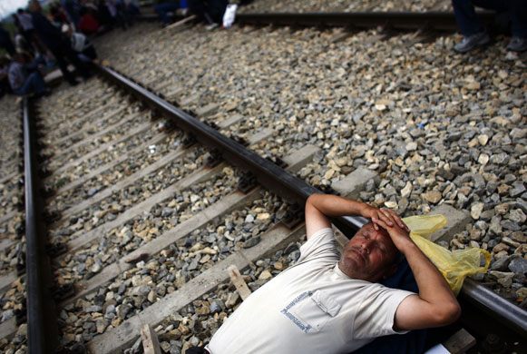 24 hours in pictures: A man sleeps on a railroad track during a protest in Serbia