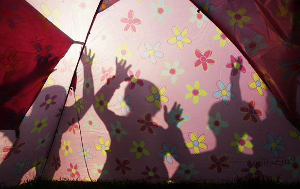 Glastonbury arrivals: Silhouettes of festival goers in a camping area at Glastonbury festival